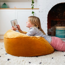 Butterscotch Velvet Floor Cushion by Castle. Girl reading. Pink tights. Black and white spot rug